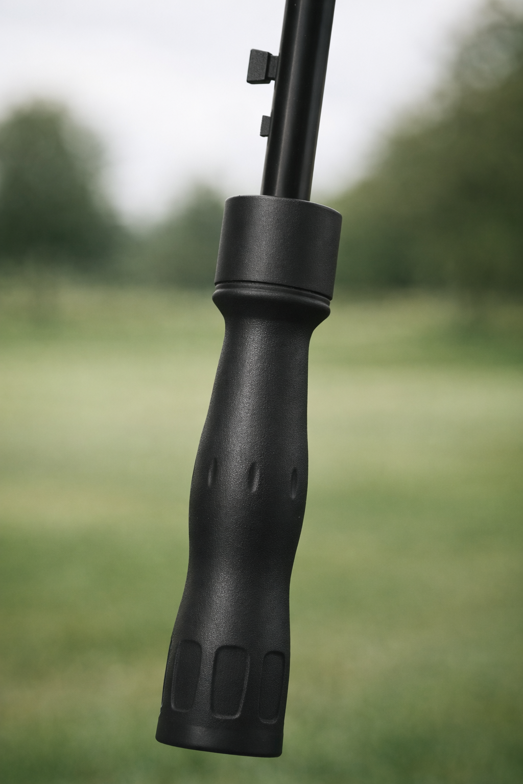 Ergonomic black sport grip umbrella handle with textured finger indents and matte finish.