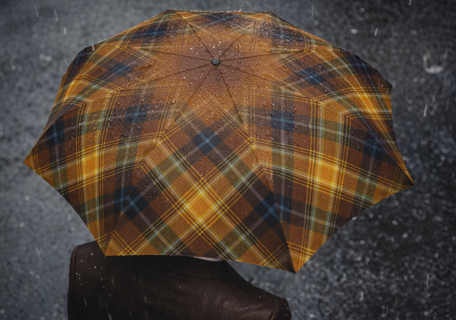 Overhead view of Angels’ Share tartan umbrella covered in rain droplets showing full check pattern.
