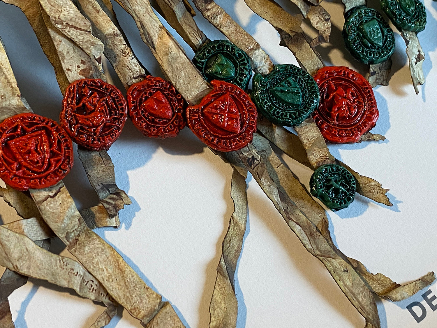 Close-up of red and green three-dimensional cast seals on the Declaration of Arbroath Fine-Art 3D Facsimile, 7th Centennial Edition.