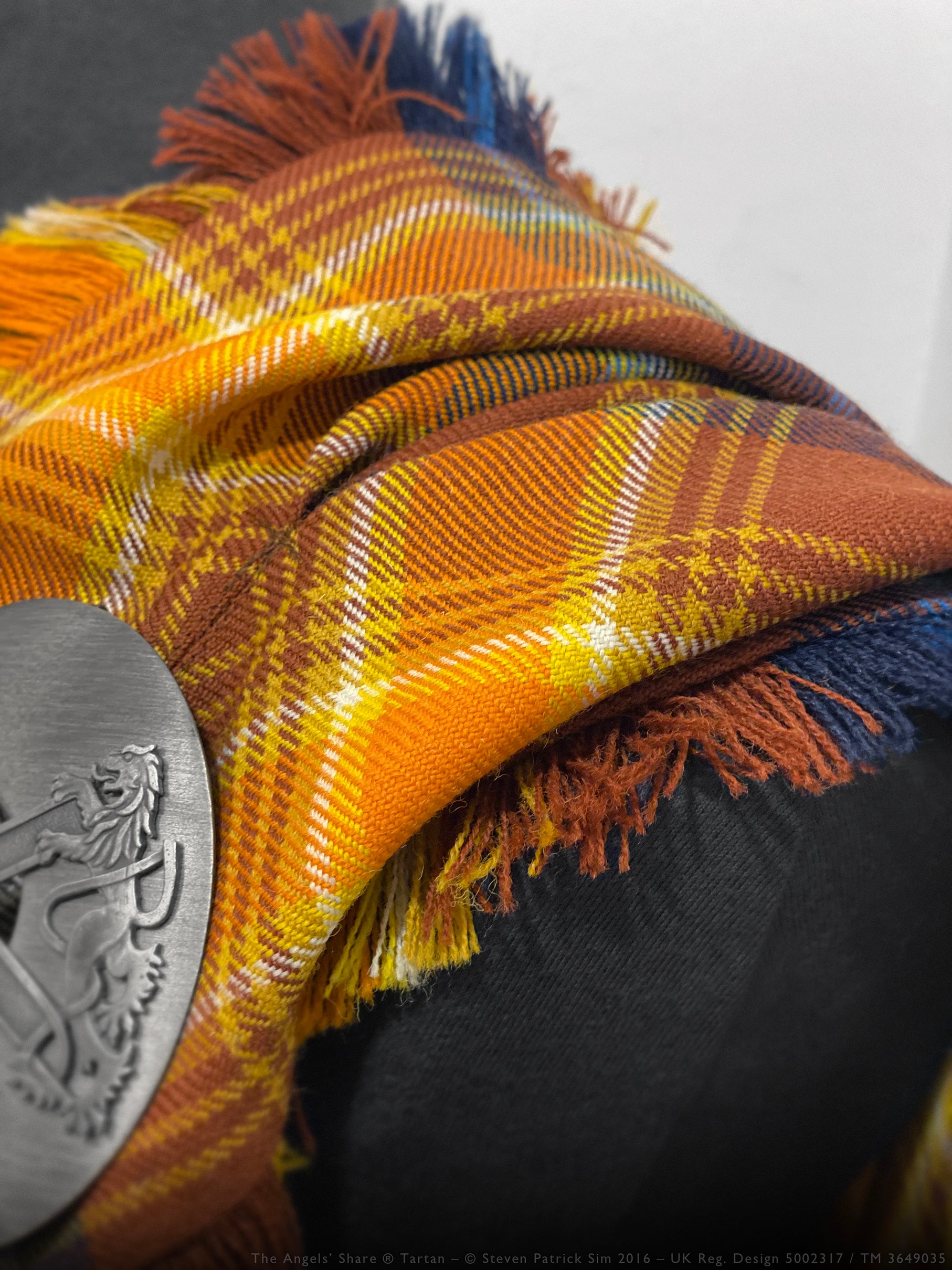 Close-up of the Angels’ Share tartan fly plaid highlighting hand-finished fringe and detailed weave.