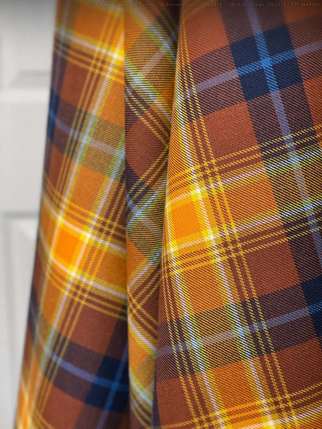 Folded Angels’ Share tartan fringed fly plaid showing depth of colour and cloth weight.