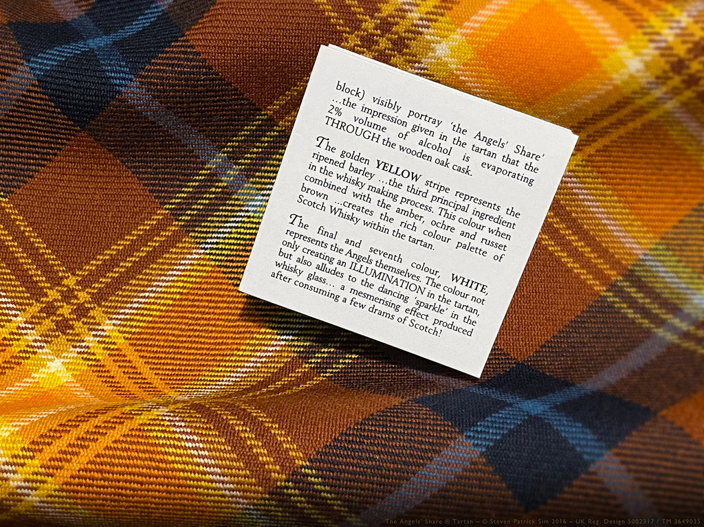 Angels’ Share tartan booklet page describing the yellow barley stripe and white illumination symbolism, placed on the tartan fabric background.