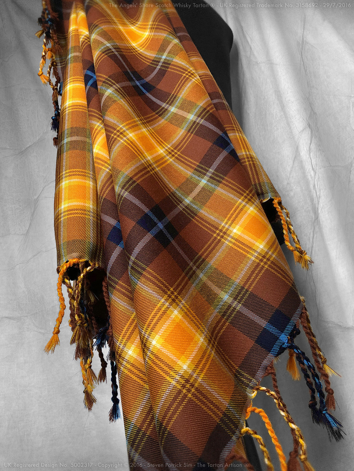 Designed by The Tartan Artisan®, this purled and knotted fly plaid in the Angels' Share® tartan celebrates Scotland’s national drink with rich symbolism and impeccable craftsmanship.