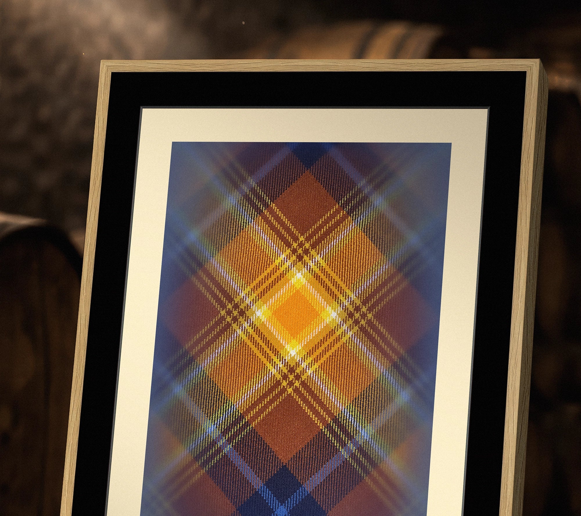 Tight crop of Angels’ Share (1494 Guardians) tartan artwork in a framed print on a whisky barrel.