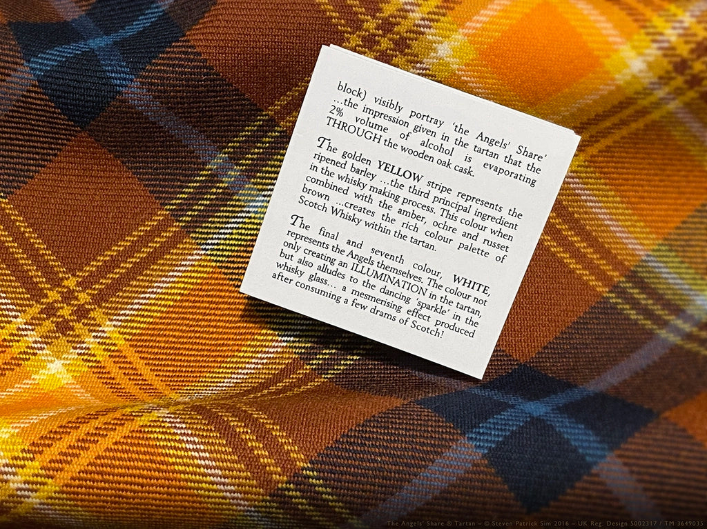 Angels’ Share tartan booklet page describing the yellow barley stripe and white illumination symbolism, placed on the tartan fabric background.