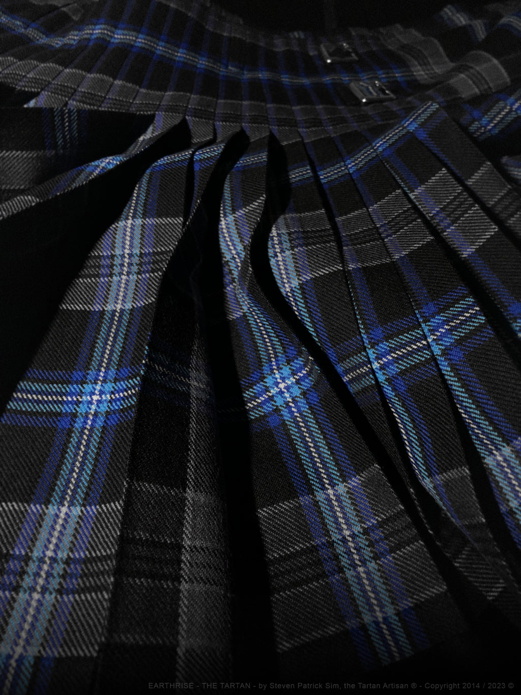 A wider variant of the Earthrise-in-the-pleats composition, revealing more of the kilt structure while maintaining the illusion of the Earth emerging from darkness.