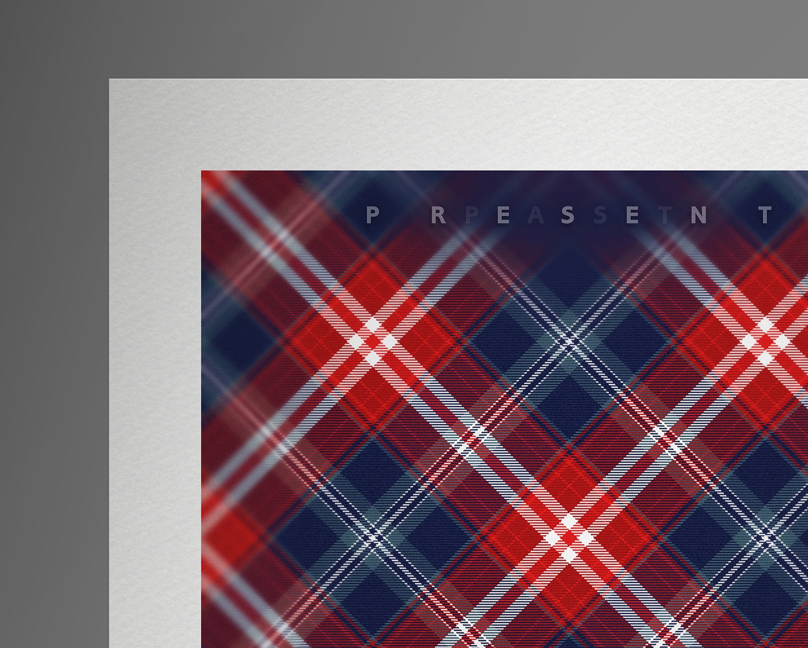 Close-up of the top-left corner of the print, highlighting the bold red and navy tartan pattern and the word "PRESENT" printed in small serif letters above the design.