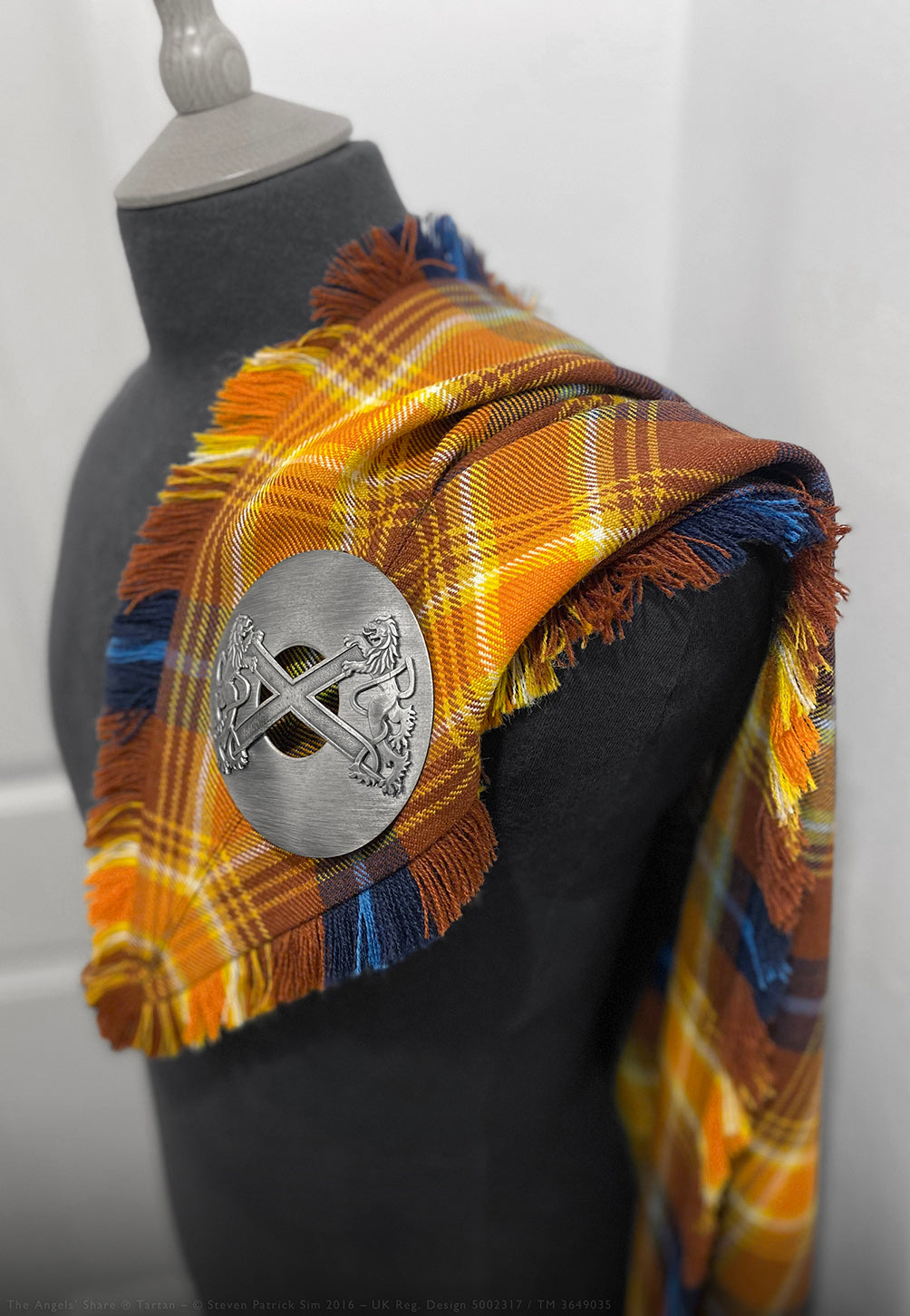 The Angels’ Share fly plaid in Scotch Whisky tartan with bright yellow and ochre overtones. Showcasing the rich golden and russet tones inspired by Scotch whisky, this fly plaid embodies the essence of the Angels’ Share tartan.
