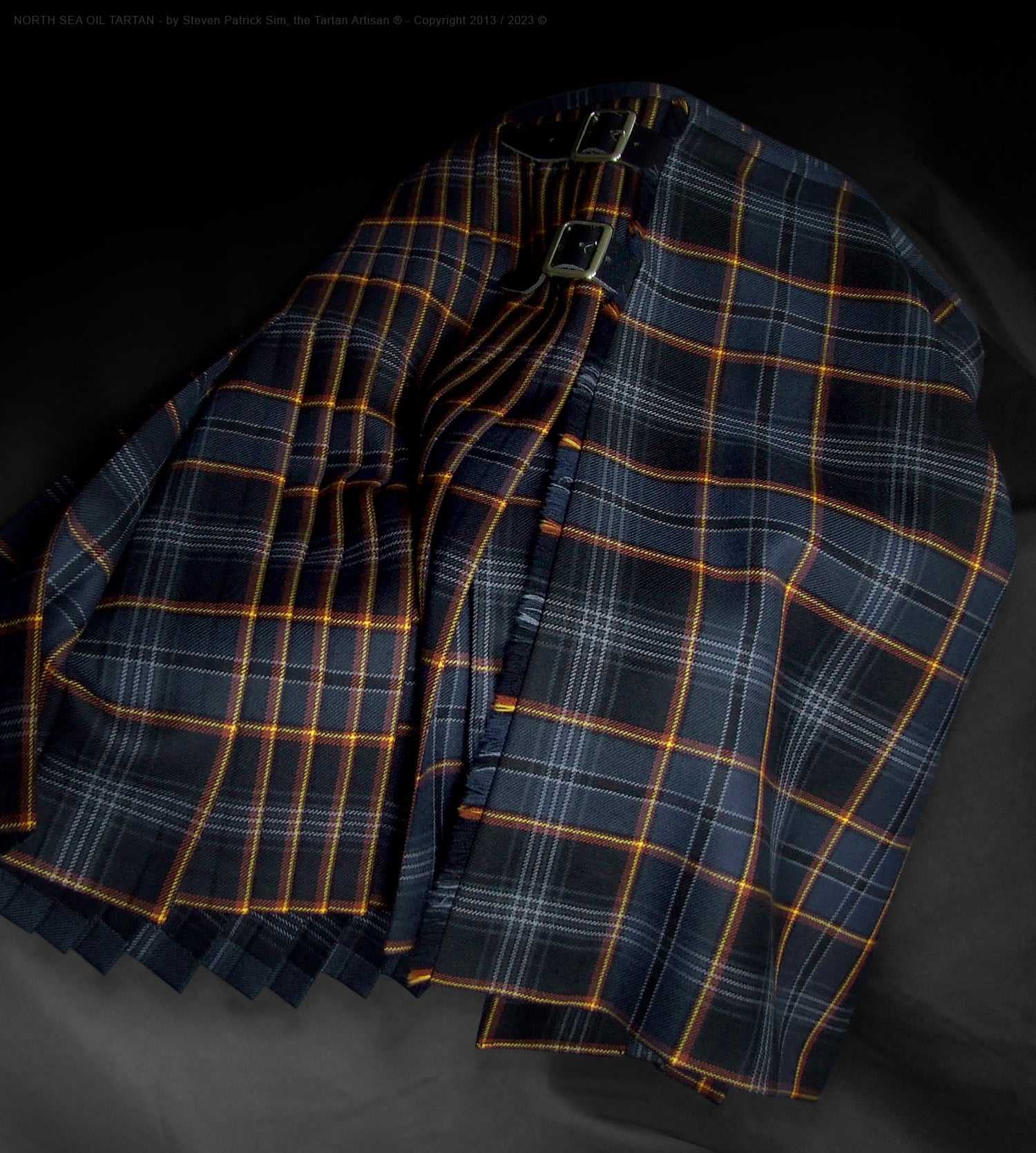 Darker variant of the 13oz North Sea Oil tartan kilt, meticulously tailored by Steven Patrick Sim the Tartan Artisan. This lighter-weight kilt features deep, intensified colors representing crude oil and the North Sea, with pleats aligned to the signature flame stripe motif. The classic design and symbolic palette commemorate Scotland’s offshore oil heritage in a contemporary, comfortable fabric.
