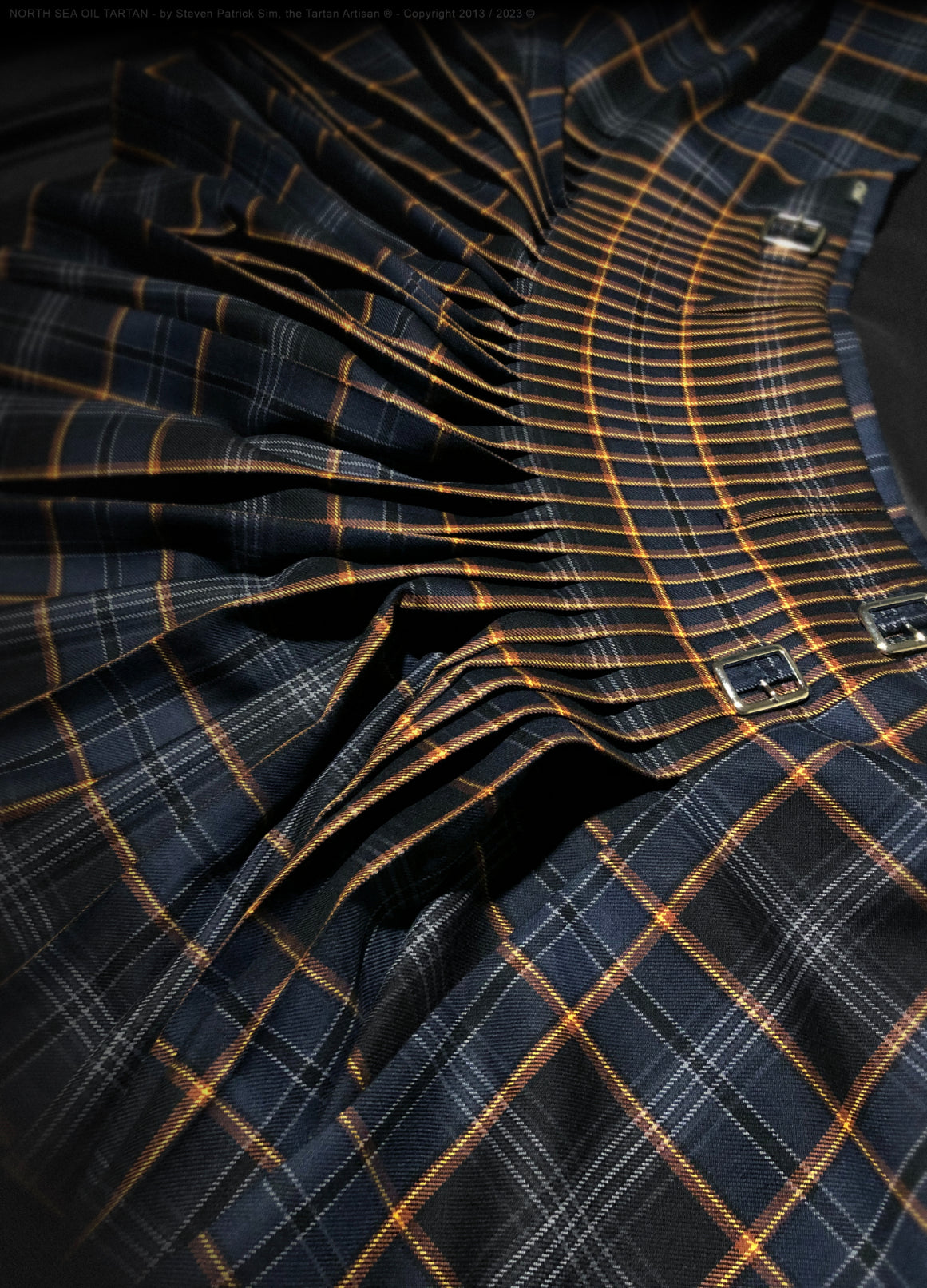 Back view of the North Sea Oil tartan kilt, pleated to the stripe, glowing with the vibrant ‘Flame of Remembrance’ motif. Expertly crafted by Steven Patrick Sim the Tartan Artisan, the kilt features bold hues reflecting crude oil, the North Sea, and the iconic flare boom, symbolizing the power, resilience, and remembrance within Scotland’s offshore oil heritage.