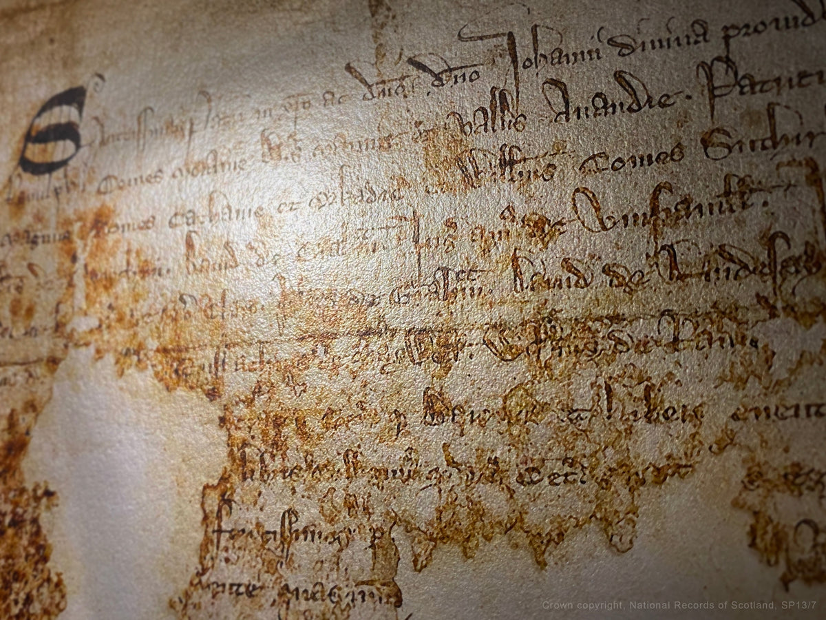 Close detail of the Declaration of Arbroath Burnished Gold fine-art print showing the manuscript roundel, historic handwriting and reflective metallic paper surface.