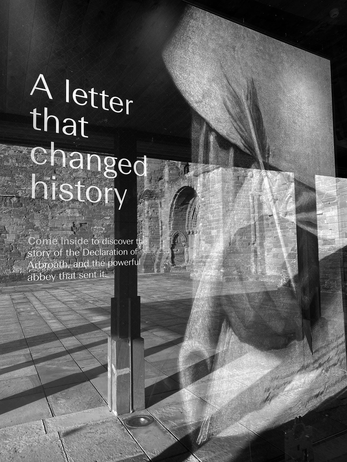 Black-and-white photograph of the “A letter that changed history” interpretation display at Arbroath Abbey, linking the site to the story of the Declaration of Arbroath.