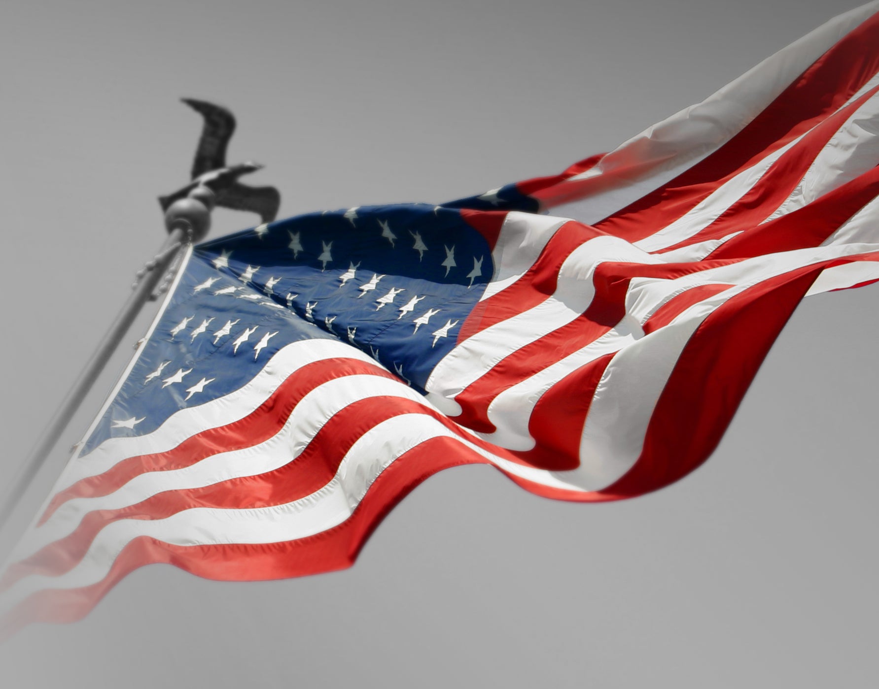 American flag waving against a gray background