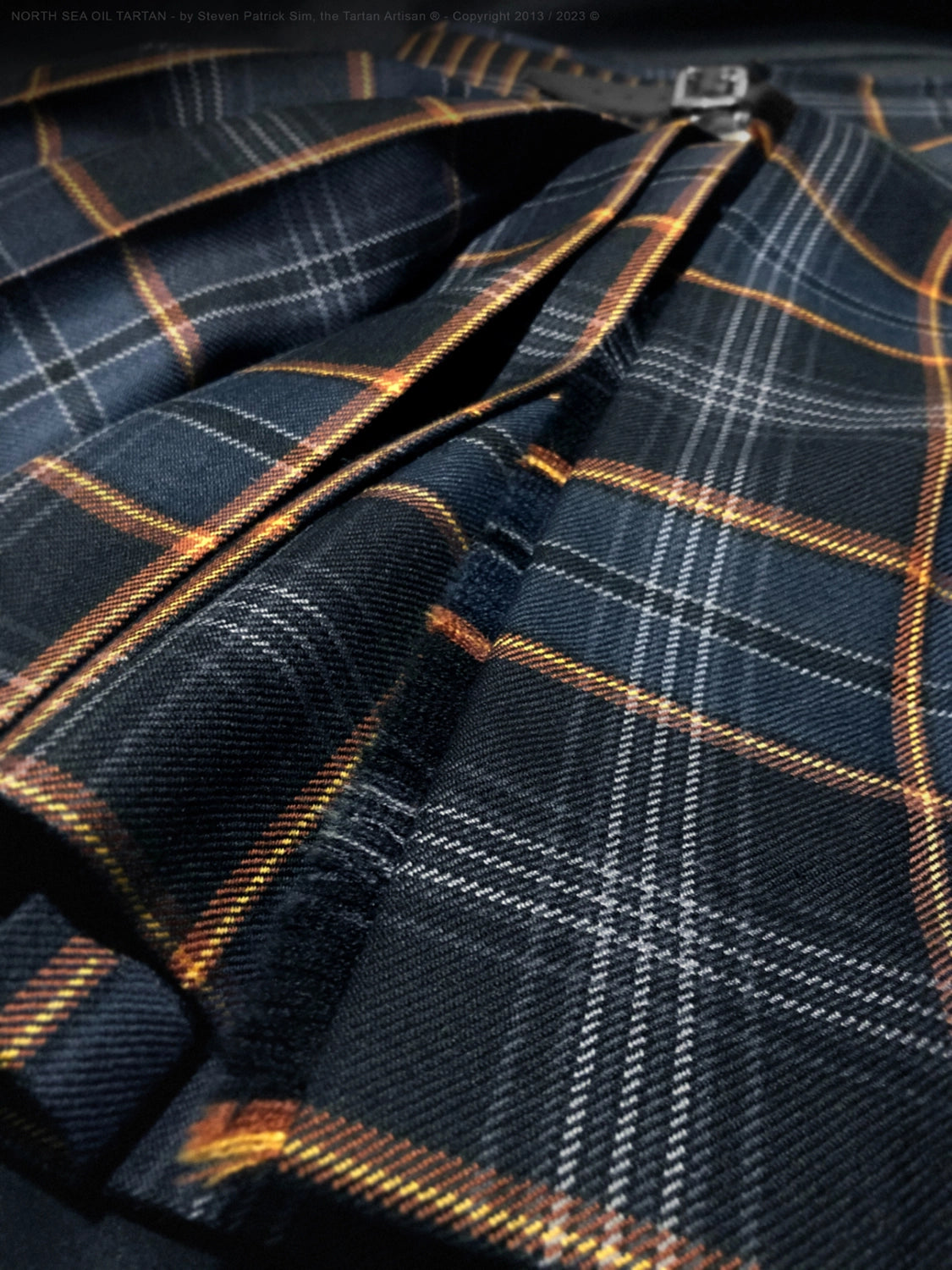 Detailed study of pleat depth and hand-finishing on the North Sea Oil tartan kilt, revealing the skill, structure, and balance required in traditional kilt making.