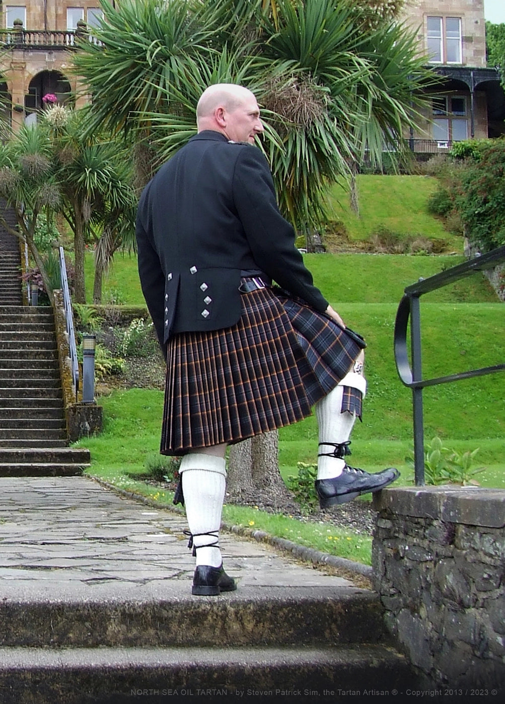 Steven Patrick Sim wearing the North Sea Oil tartan kilt at the Glenburn Hotel on the Isle of Bute, presenting the tartan in a refined architectural setting.