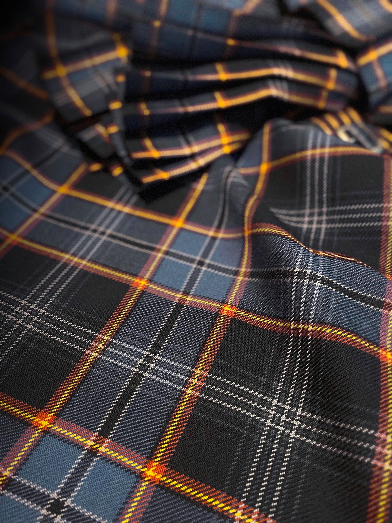 Detailed study of the pleated sett and fabric texture of the North Sea Oil tartan kilt, showing depth, symmetry, and craftsmanship.