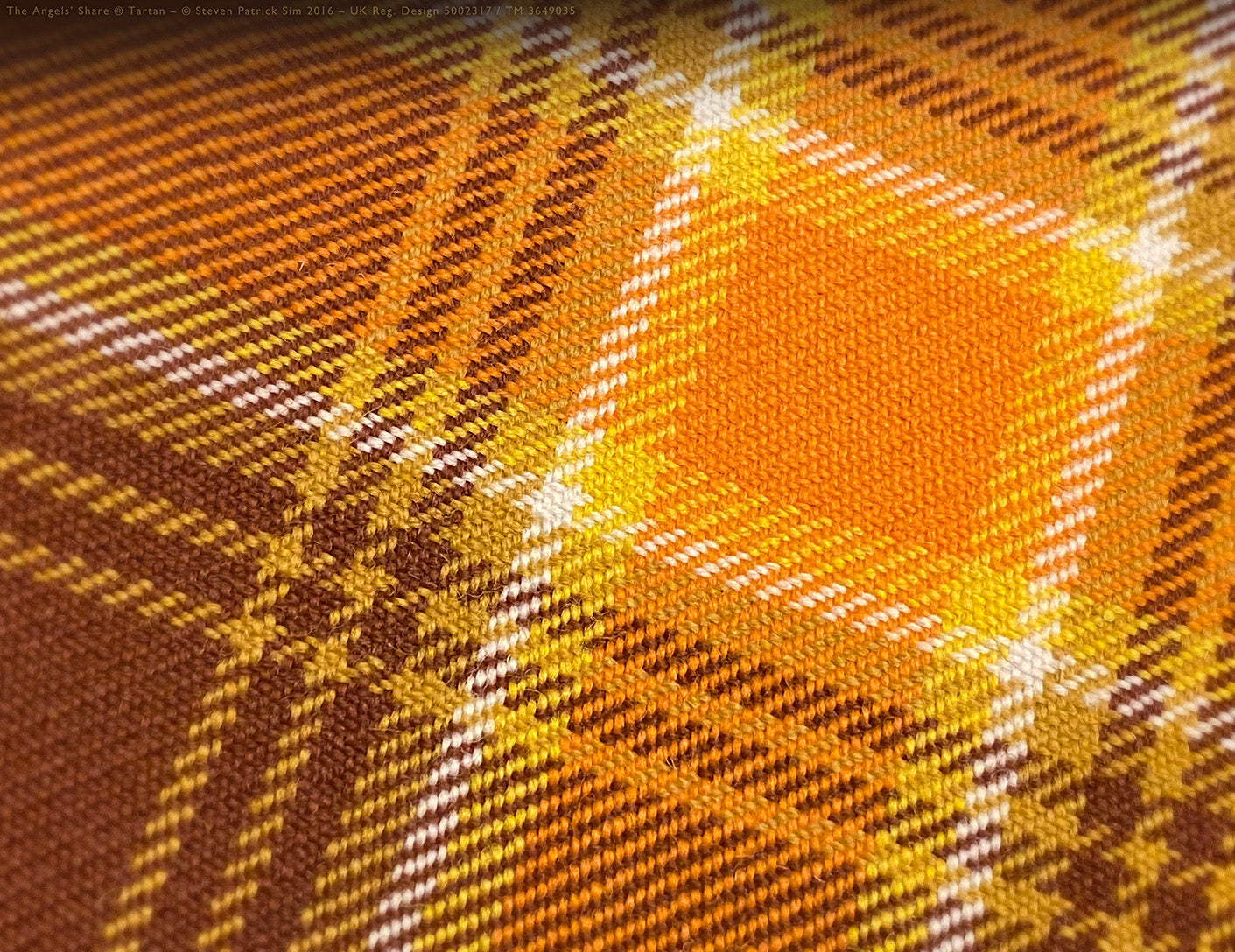 Clean sett detail of The Angels’ Share® tartan — balanced lines of brown, ochre, blue and gold in perfect geometry. The kilt sett revealed — harmony in every crossing.